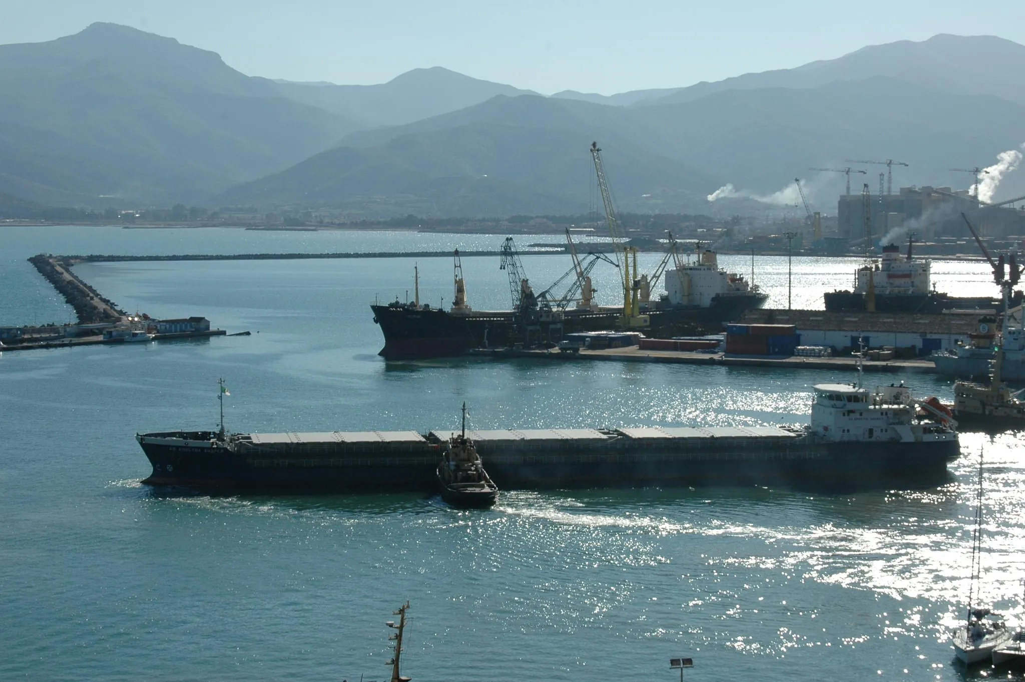 Port of Béjaïa: cargo ships, cranes, containers and industrial works on the coast